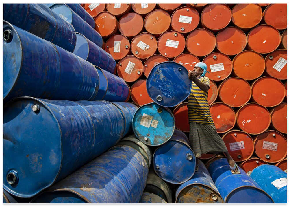 Worker sorting colorful oil drums